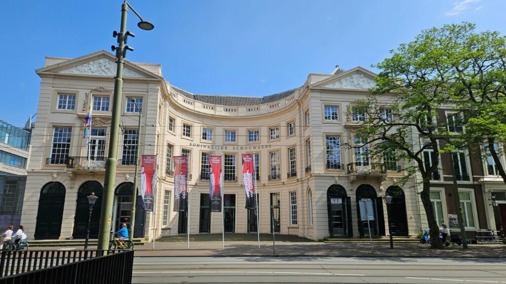 Elegant building with banners and trees.